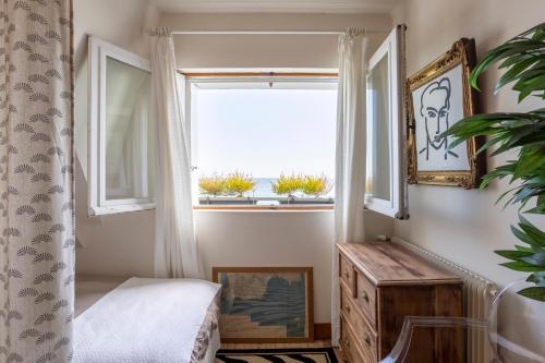 a bedroom with a window and a wooden dresser at Villa avec vue sur mer imprenable in Loctudy