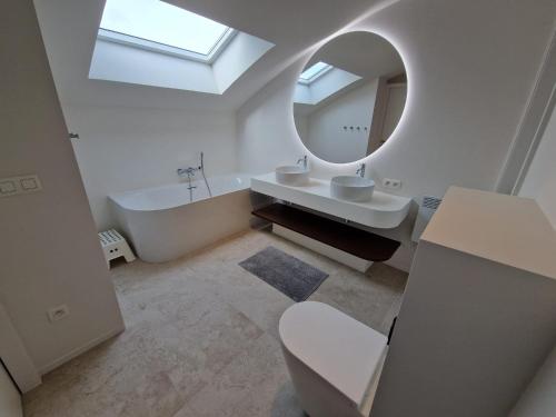 a bathroom with a sink and a mirror and a tub at Villa Louise Nieuwpoort-Bad in Nieuwpoort