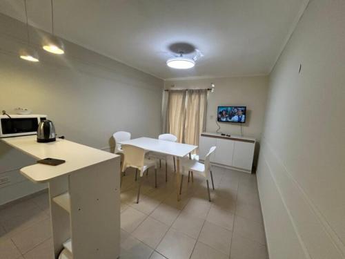 Una cocina y un comedor con mesa y sillas. en HOUSE AND SUITE SF RIVADAVIA, en Santa Fe