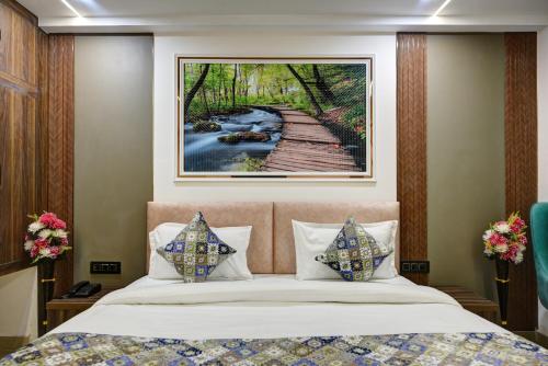a bedroom with a bed with a painting on the wall at Hotel Dream World - Free Airport Drop in New Delhi
