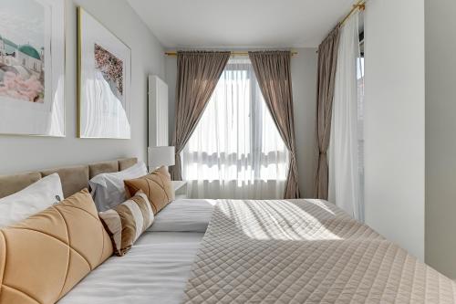 a bedroom with a large bed in front of a window at Scala City Center Magic Apartments with Parking by Lion Apartments in Gdańsk