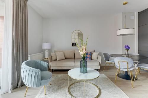 a living room with a vase of flowers on a table at Scala City Center Magic Apartments with Parking by Lion Apartments in Gdańsk
