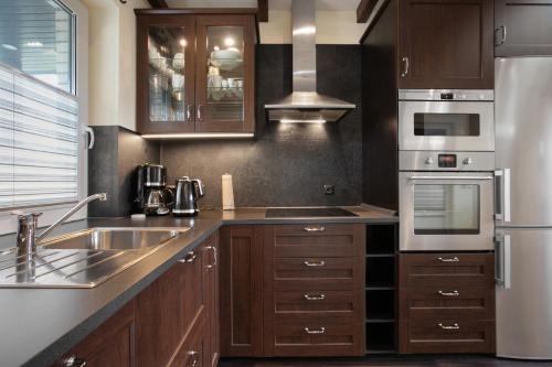 a kitchen with wooden cabinets and stainless steel appliances at Ferienhaus Martje in Hennstedt