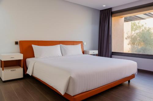 a bedroom with a large white bed and a window at Atelier Loft Oliver Palm Resort in Marrakesh