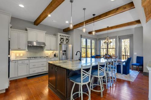 a kitchen with white cabinets and a large island with bar stools at Lakefront Getaway Dock Fire Pit & Games in Seneca