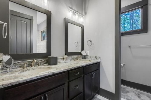 a bathroom with two sinks and a large mirror at Lakefront Getaway Dock Fire Pit & Games in Seneca
