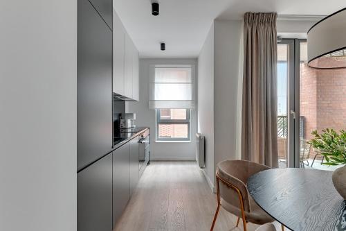 a kitchen with a table and a dining room at Scala City Center Magic Apartments with Parking by Lion Apartments in Gdańsk