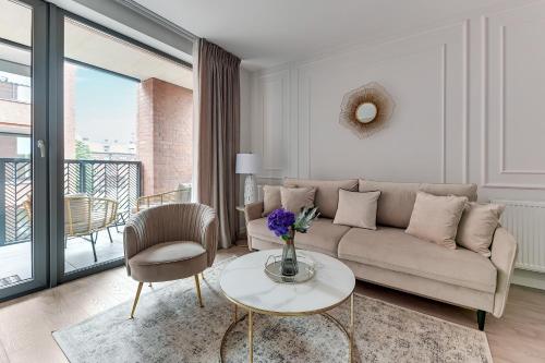 a living room with a couch and a table at Scala City Center Magic Apartments with Parking by Lion Apartments in Gdańsk