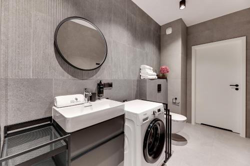 a bathroom with a sink and a washing machine at Scala City Center Magic Apartments with Parking by Lion Apartments in Gdańsk