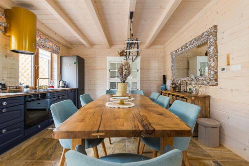 a dining room with a wooden table and blue chairs at Słoneczna Wetlina Dom in Wetlina