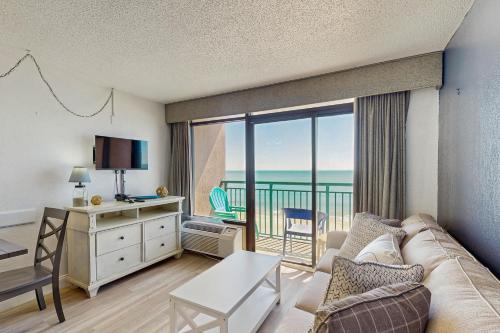a living room with a couch and a view of the ocean at Sandcastle South 615 in Myrtle Beach