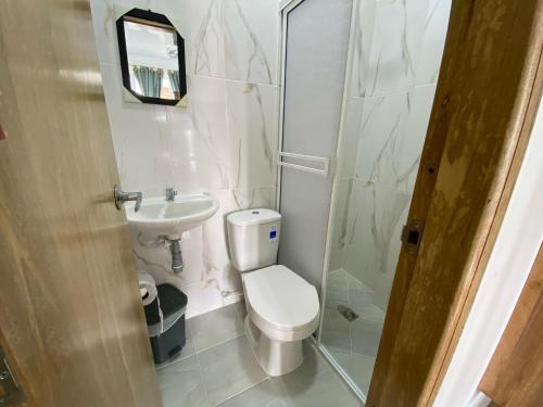 a bathroom with a toilet and a sink and a shower at Hotel Panther Resort in Necoclí