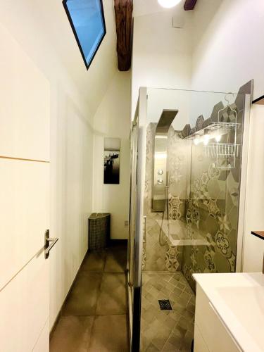 une douche avec une porte vitrée dans une salle de bain dans l'établissement L'Atelier - Coeur de ville, à La Rochelle