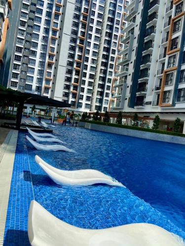 a swimming pool with several white objects on it with buildings at K AVENUE B17 house room near airport by Gc in Kota Kinabalu