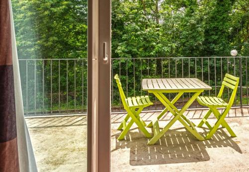 a picnic table and two chairs on a patio at B&B HOTEL Quimper Sud Bénodet in Quimper