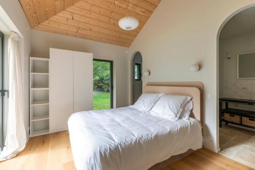 a bedroom with a bed and a large window at Villa des Résiniers, proche plage & forêt, wifi in Moliets-et-Maa