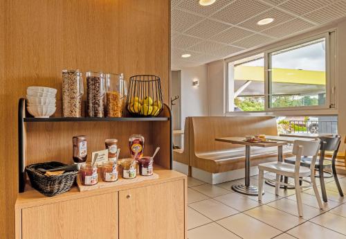 a kitchen with a table and a dining room at B&B HOTEL Quimper Sud Bénodet in Quimper