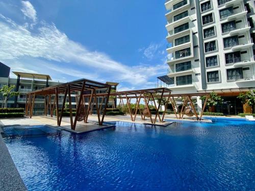 a swimming pool with benches in front of a building at K AVENUE GC studio in Kota Kinabalu