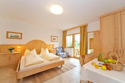 a bedroom with a bed and a table with fruit on it at Gleifhof in Appiano sulla Strada del Vino