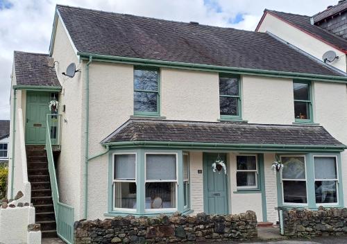 a white and green house with a green door at Aura in Keswick
