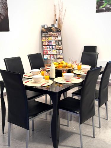 - une table à manger noire avec des chaises et des fruits dans l'établissement Le Paradis Caché, à Causses-et-Veyran