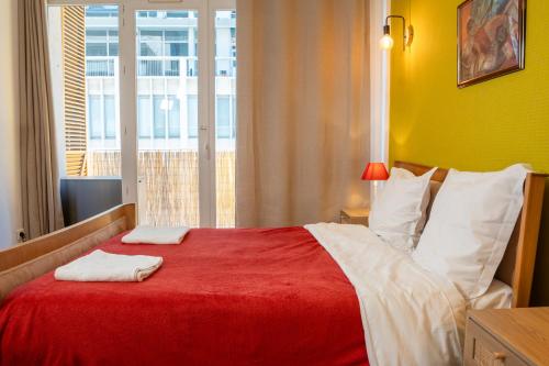 トゥーロンにあるEscapade entre ville et mer, terrasse ensoleilléeのベッドルーム1室(赤いベッド1台、タオル2枚付)