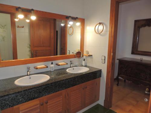 Un baño con dos lavabos y un espejo grande. en Villa en Andratx con piscina privada, en Andratx