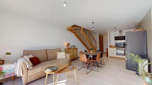 un salon avec un canapé et une table et une cuisine dans l'établissement Merlyne Beach Villa 7, à Saint-Gilles-Croix-de-Vie