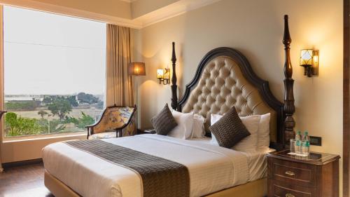 a bedroom with a large bed with a large window at Golden galaxy hotels and resorts pvt ltd in Pīrthala