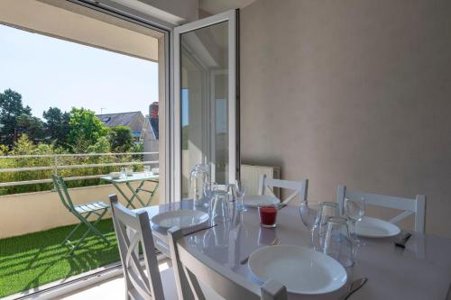 une table blanche avec des chaises et des verres sur un balcon dans l'établissement Le Filage - Balcon - Wifi, à Laval