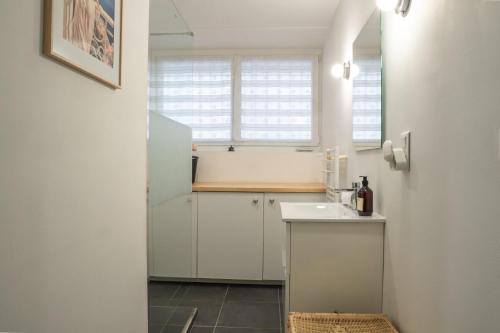 トゥーロンにあるEscapade entre ville et mer, terrasse ensoleilléeの白いキャビネットとシンクを備えた小さなキッチン