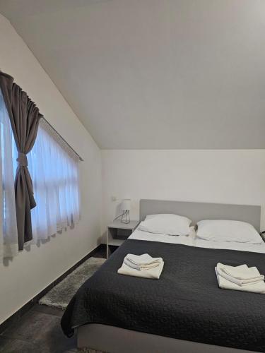 a bedroom with a bed with two towels on it at Filipovic rent a car & apartments in Selnica Šćitarjevska