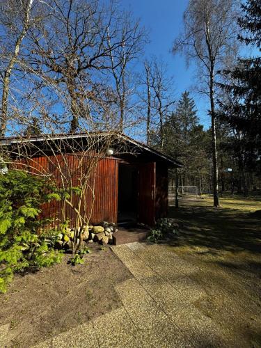 a smallshed with a red building in a park at ahoj PRZYLESIE in Pobierowo