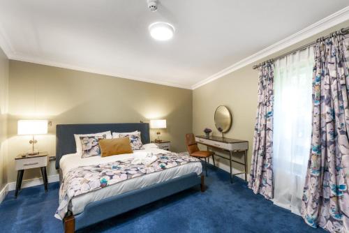 a bedroom with a bed and a desk and a window at Troysgate House in Kilkenny