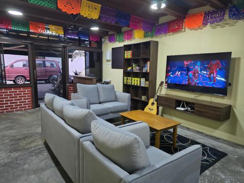 マラッカにあるLa Mamasita Hostel, Jonker Street Melaka Townのソファと薄型テレビのあるリビングルーム