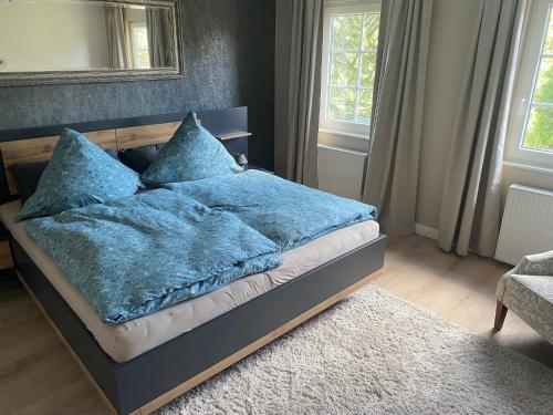 a bed with blue blankets and pillows in a bedroom at Ferienhaus auffm Hebberg in Attendorn