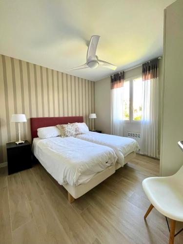 une chambre avec un grand lit avec un ventilateur de plafond dans l'établissement Southwest Hossegor, à Capbreton