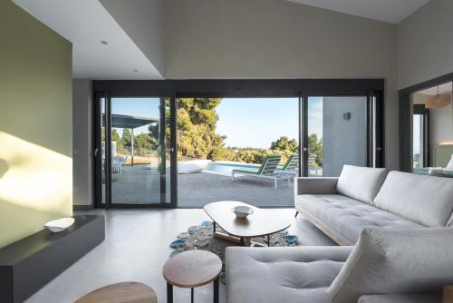 a living room with a couch and a table at Theeta Villas by RentalsPro - Metamorfosi Halkidiki in Metamorfosi