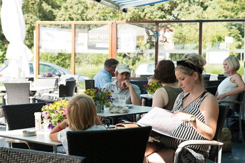 a group of people sitting at tables in a restaurant at Strandhotel Duinoord in Vrouwenpolder