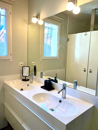 une salle de bain avec un lavabo et un grand miroir dans l'établissement Southwest Hossegor, à Capbreton