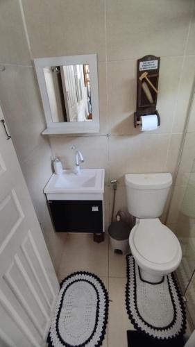 a small bathroom with a toilet and a sink at CASA DU VÔ - Cantinho Du Vô in Santa Teresa