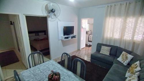ein Wohnzimmer mit einer Couch und einem Tisch und einem Fernseher in der Unterkunft CASA DU VÔ - Cantinho Du Vô in Santa Teresa