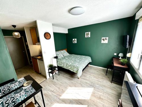 une chambre avec un lit et un mur végétal dans l'établissement Studio Le république 2, à Dijon