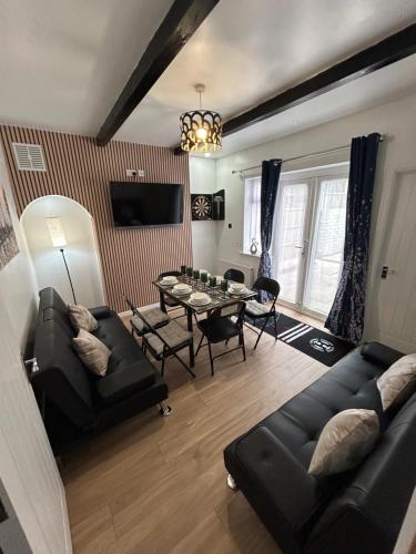 a living room with a couch and a table at Spaghetti House - 6 Bedroom Contractor House Sleeps 12 Parking for 3 Vans Bromford Duddeston Fort Dunlop Star City HS2 in Birmingham