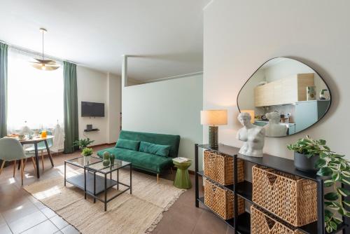 a living room with a green couch and a mirror at Bazzi, 49 - Bocconi University in Milan