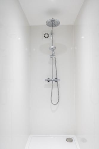 a shower in a bathroom with a shower head at Stunning little house, 2 mins from Lyme Regis beach with a sea view to die for. Sleeps 2, free parking, small dog welcome. in Lyme Regis