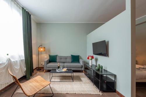 a living room with a couch and a tv at Bazzi, 49 - Bocconi University in Milan