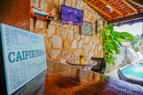 a bar with a sign on a stone wall at Pousada Do Forte in Paraty