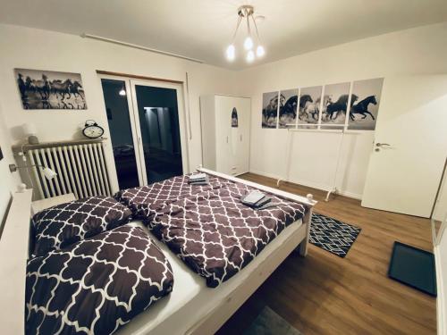 a bedroom with a bed with a brown and white comforter at Ferienwohnung Hohensonne in Aach