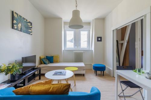 un salon avec un canapé et une table dans l'établissement Neustadt central et paisible, à Strasbourg